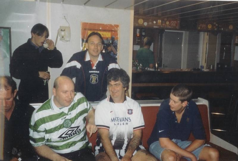 SG2 Mark Blue on phone. Dave McIntyre in Celtic Shirt, Stewart Davidson in Rangers shirt 
